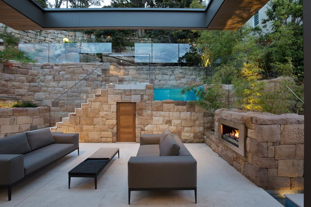 Contemporary patio in Sydney with with fireplace.