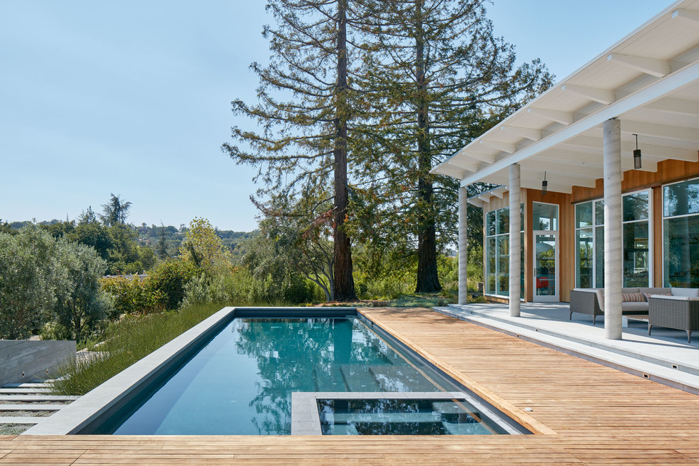 This is an example of a contemporary backyard rectangular pool in San Francisco with a hot tub and concrete pavers.