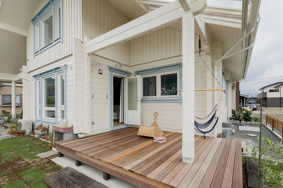 This is an example of a scandinavian deck in Other with a roof extension.