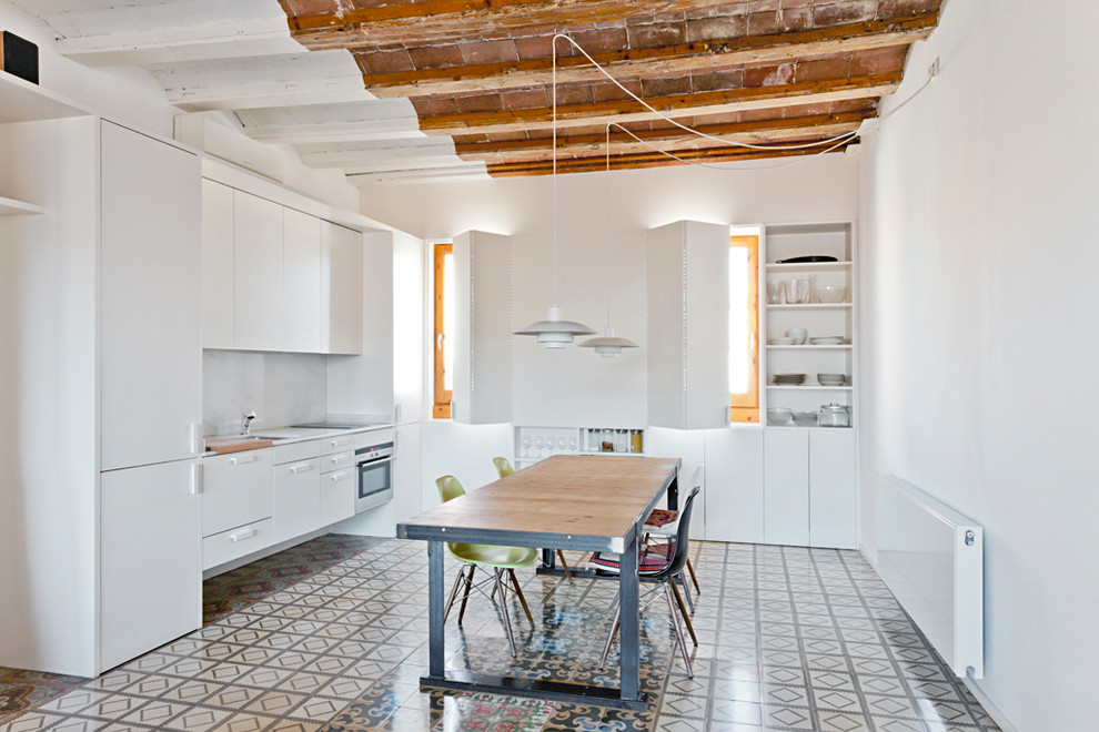 Photo of a small mediterranean single-wall open plan kitchen in Barcelona with a single-bowl sink, flat-panel cabinets, light wood cabinets, marble benchtops, white splashback, marble splashback, panelled appliances, cement tiles, no island and white benchtop.