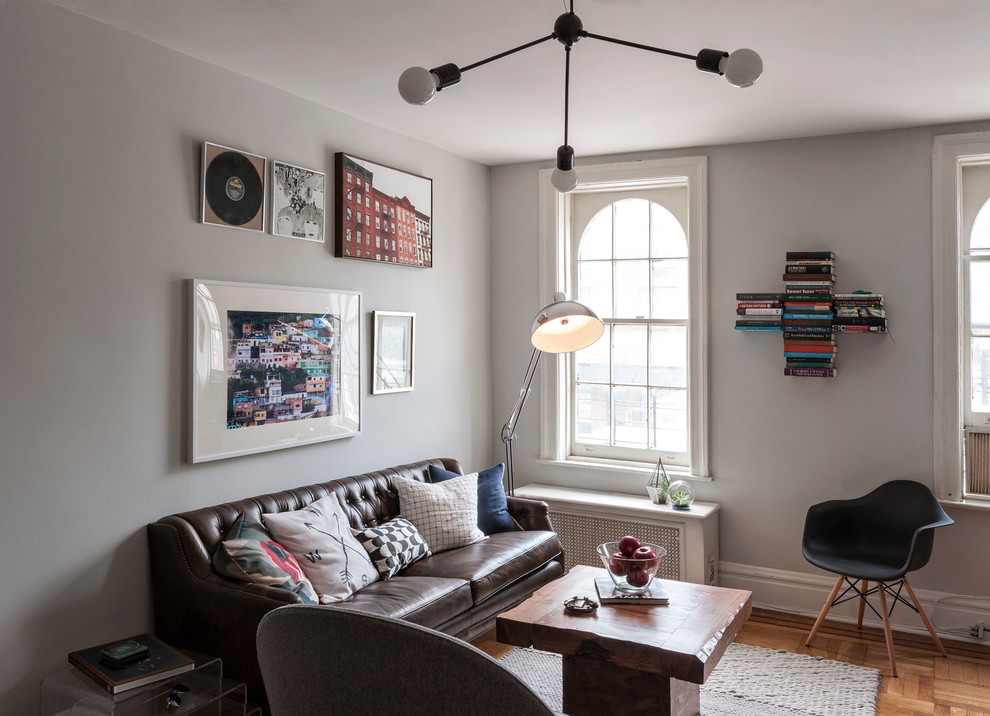 This is an example of a mid-sized eclectic open concept living room in New York with a library and grey walls.