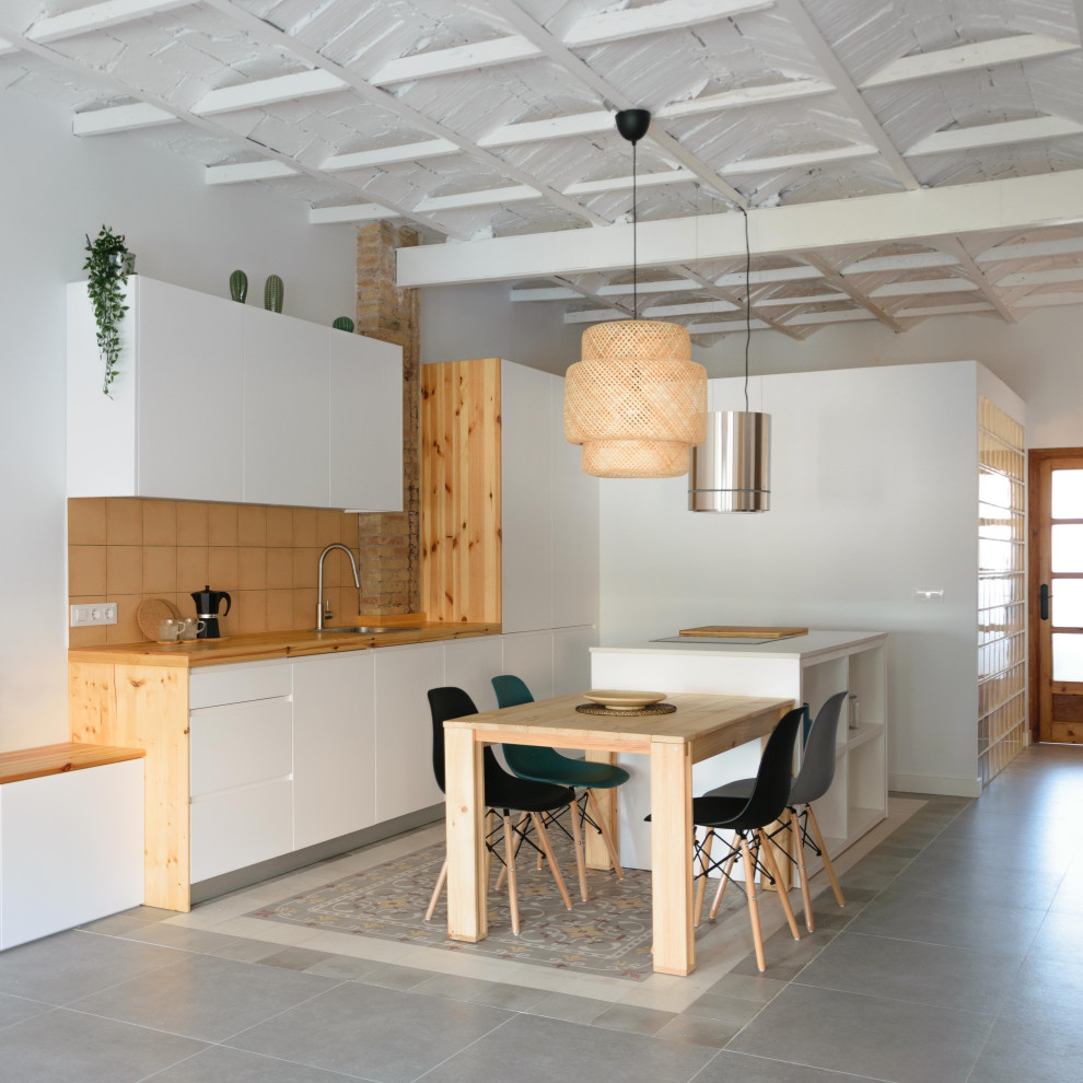 Bild på ett mellanstort medelhavsstil linjärt kök med öppen planlösning, med en enkel diskho, släta luckor, vita skåp, gult stänkskydd, stänkskydd i keramik, klinkergolv i keramik, en köksö och grått golv
