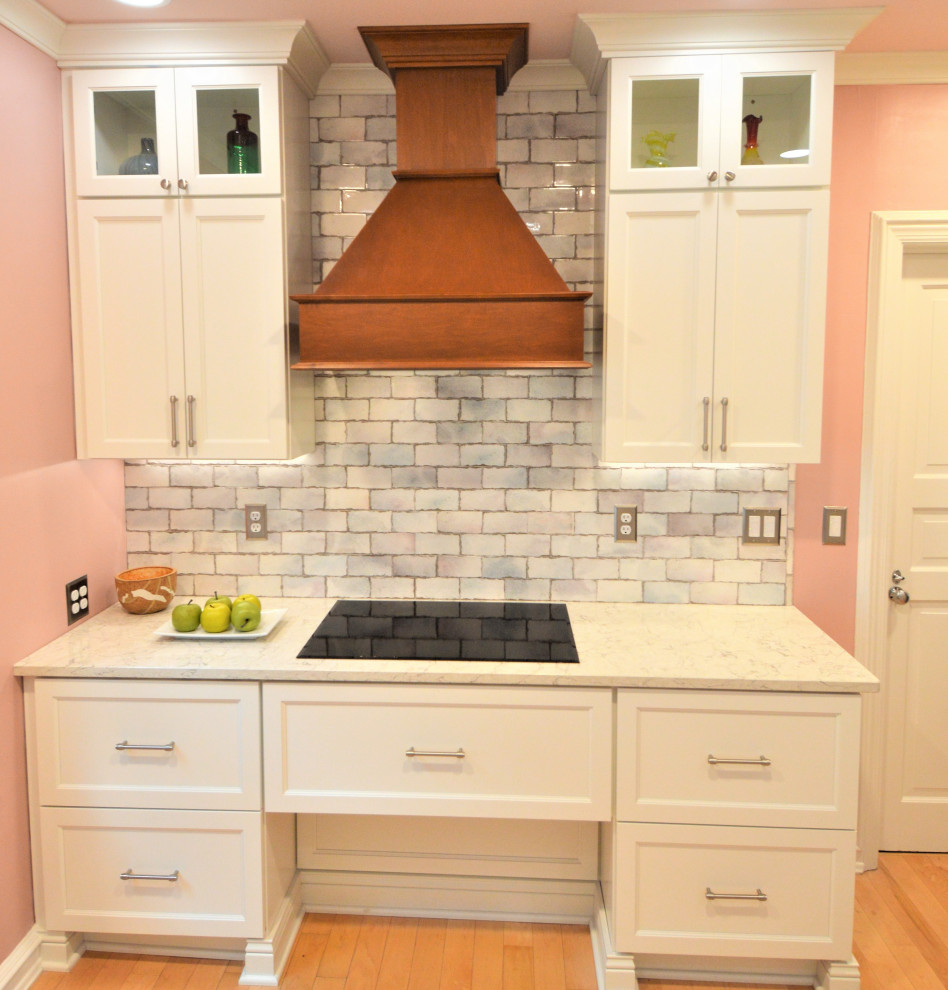 Example of a small transitional light wood floor kitchen design in Milwaukee with a single-bowl sink, shaker cabinets, white cabinets, quartzite countertops, ceramic backsplash and stainless steel appliances