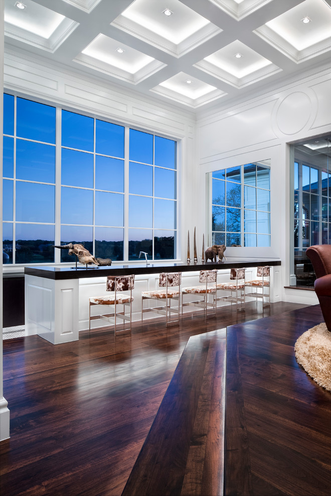 Large modern open concept living room in Austin with a home bar, white walls, dark hardwood floors and brown floor.