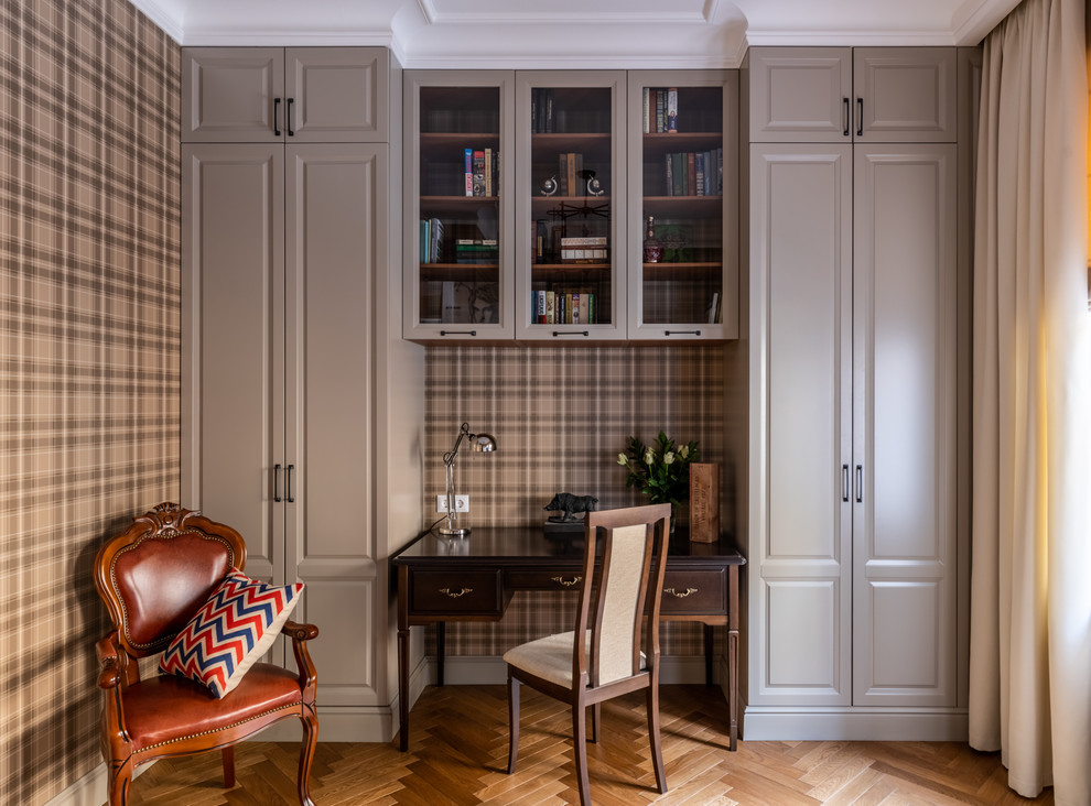 This is an example of a mid-sized traditional study room in Moscow with medium hardwood floors, a freestanding desk, brown floor and brown walls.