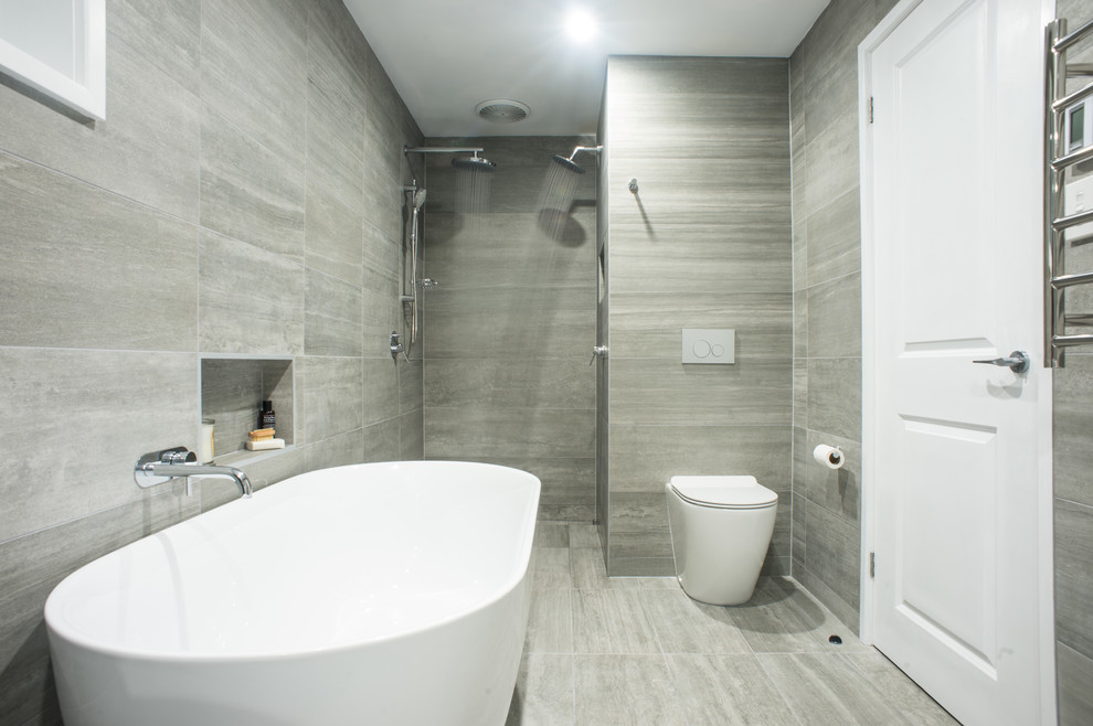 Design ideas for a large contemporary master bathroom in Sydney with a freestanding tub, an open shower, a one-piece toilet, gray tile, porcelain tile, grey walls and porcelain floors.