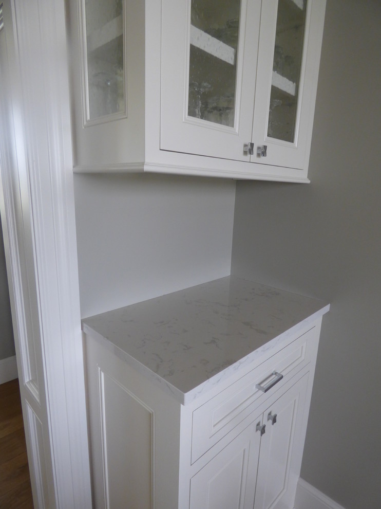 Inspiration for a large transitional l-shaped light wood floor eat-in kitchen remodel with an undermount sink, recessed-panel cabinets, white cabinets, quartz countertops, white backsplash, subway tile backsplash, stainless steel appliances and an island