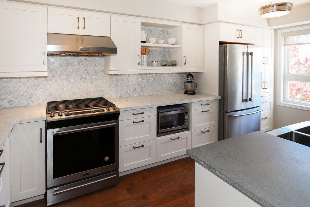 Photo of a mid-sized contemporary galley separate kitchen in Toronto with a double-bowl sink, shaker cabinets, white cabinets, grey splashback, ceramic splashback, stainless steel appliances, dark hardwood floors and brown floor.
