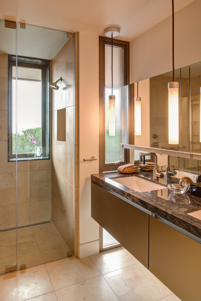 Inspiration for a large contemporary master bathroom in San Francisco with an undermount sink, flat-panel cabinets, light wood cabinets, granite benchtops, a curbless shower, a one-piece toilet, beige tile, stone tile, beige walls and porcelain floors.