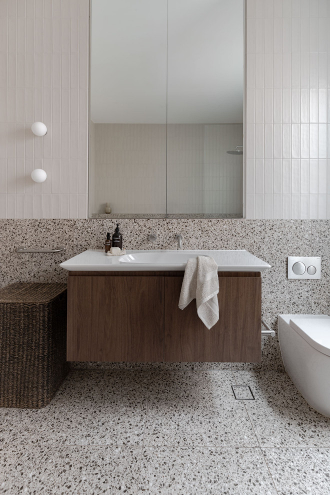 Large transitional master bathroom in Sydney with flat-panel cabinets, dark wood cabinets, a freestanding tub, an open shower, a one-piece toilet, white tile, ceramic tile, white walls, terrazzo floors, an integrated sink, grey floor, white benchtops, a single vanity and a floating vanity.