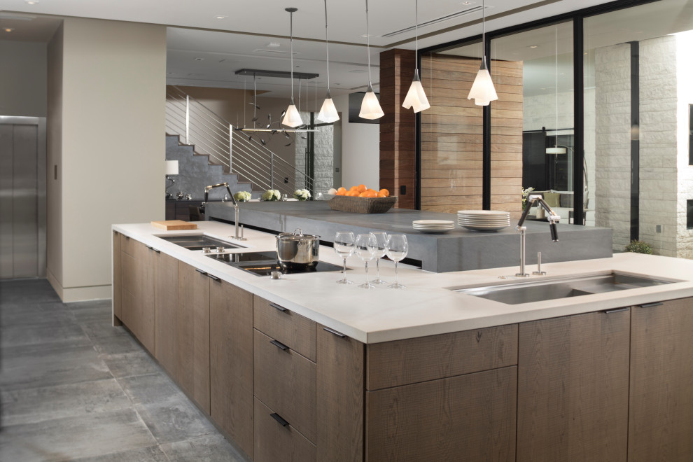 Photo of an expansive contemporary l-shaped open plan kitchen in Las Vegas with an undermount sink, flat-panel cabinets, quartz benchtops, stainless steel appliances, porcelain floors, with island, grey floor, white benchtop and medium wood cabinets.