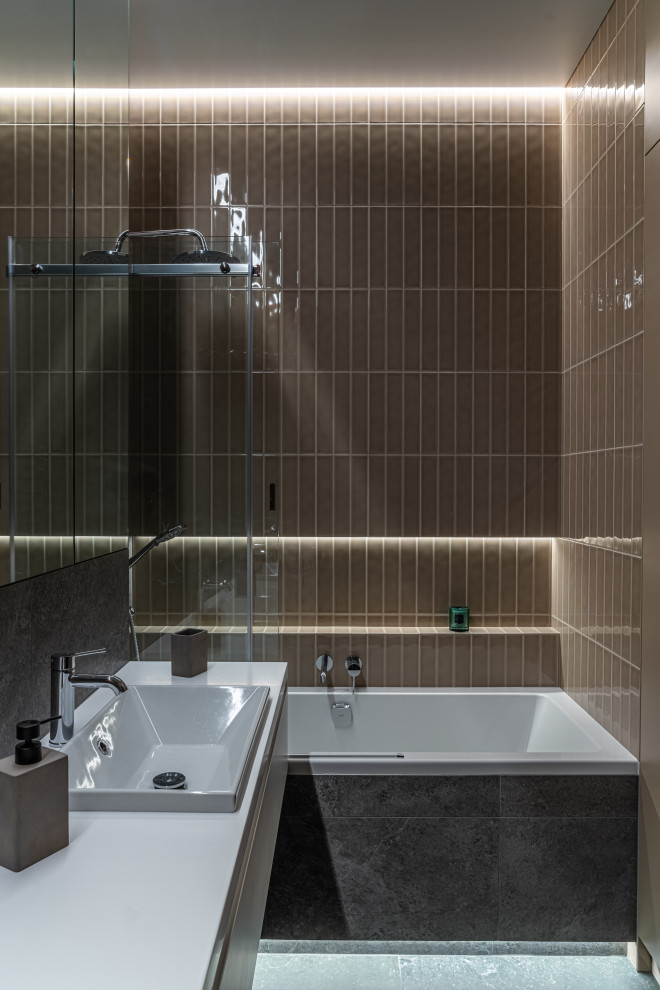 Inspiration för ett mellanstort funkis grå grått en-suite badrum, med grå skåp, ett undermonterat badkar, en bidé, brun kakel, stickkakel, grå väggar, klinkergolv i keramik, ett undermonterad handfat, granitbänkskiva och grått golv