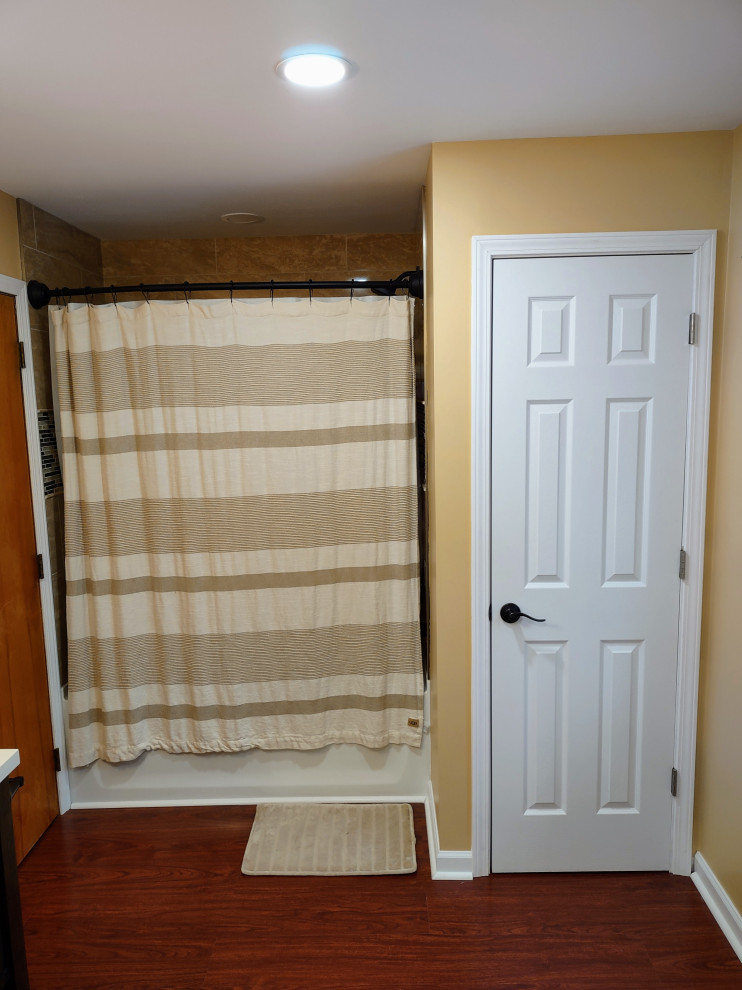 Idéer för att renovera ett mellanstort vintage beige beige en-suite badrum, med luckor med infälld panel, skåp i mörkt trä, ett platsbyggt badkar, en dusch/badkar-kombination, en toalettstol med separat cisternkåpa, laminatgolv, ett nedsänkt handfat, laminatbänkskiva, brunt golv, dusch med duschdraperi och orange väggar