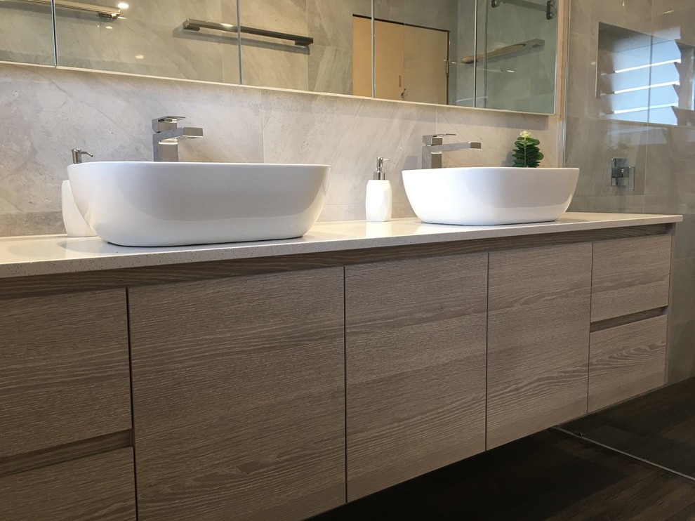 Design ideas for a small modern master bathroom in Brisbane with raised-panel cabinets, light wood cabinets, a corner shower, a wall-mount toilet, gray tile, ceramic tile, grey walls, ceramic floors, a wall-mount sink, soapstone benchtops, brown floor, a sliding shower screen and white benchtops.