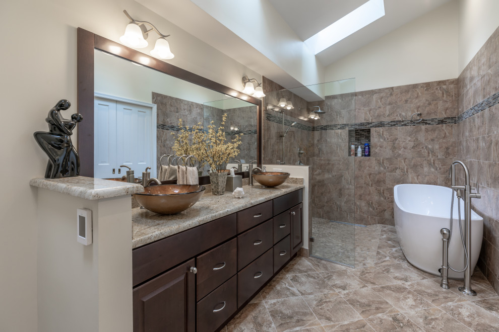 Small trendy master gray floor and double-sink bathroom photo in DC Metro with brown cabinets, a one-piece toilet, beige walls, a vessel sink, brown countertops and a built-in vanity