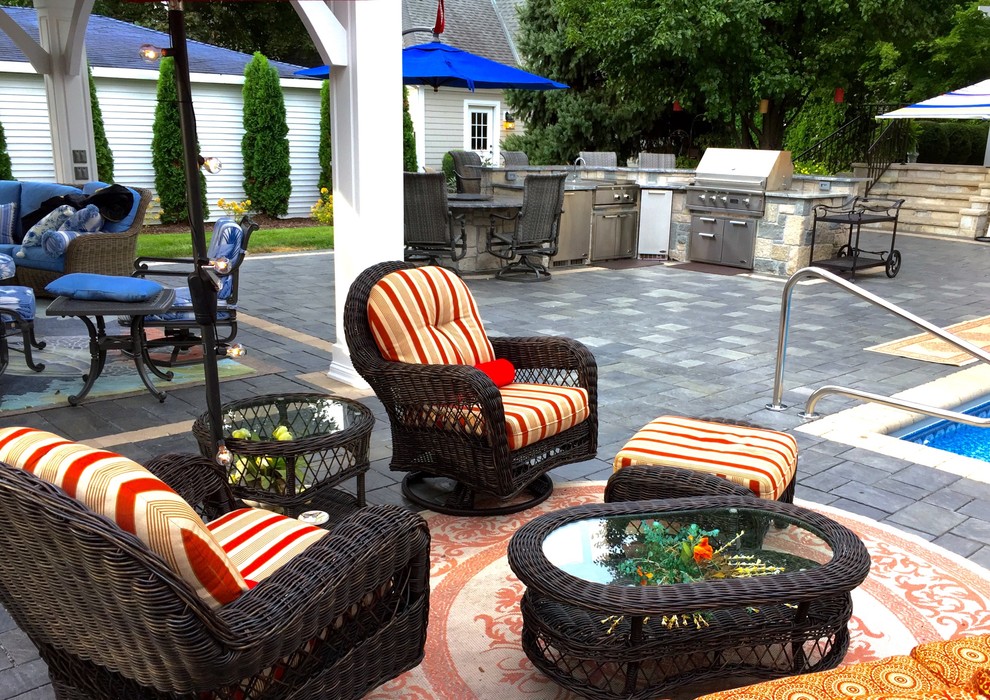 Inspiration for a traditional backyard patio in Chicago with brick pavers, a gazebo/cabana and an outdoor kitchen.