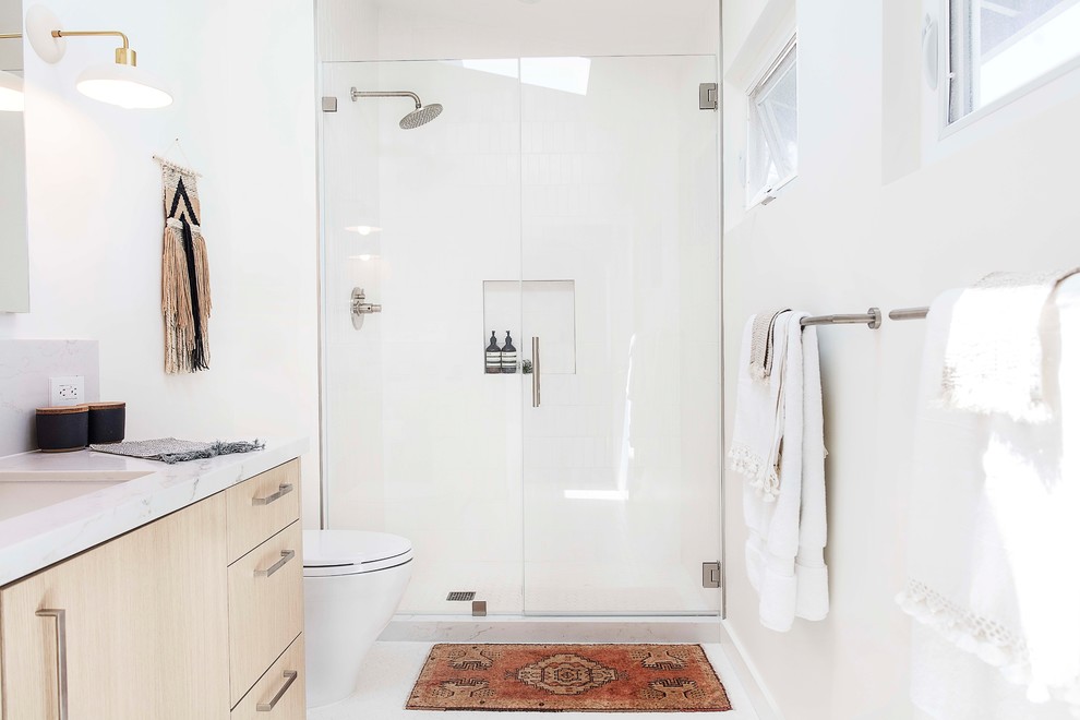 Alcove shower - mid-sized contemporary 3/4 mosaic tile floor and white floor alcove shower idea in San Francisco with flat-panel cabinets, light wood cabinets, white walls, an undermount sink, quartzite countertops, a hinged shower door and gray countertops