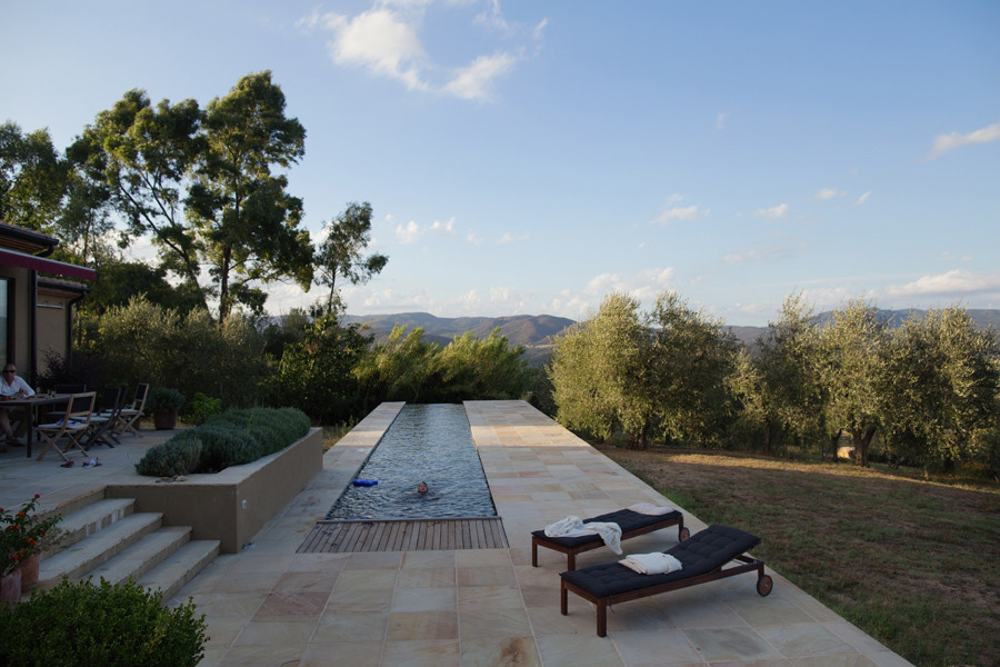 Großer, Gefliester Mediterraner Infinity-Pool hinter dem Haus in rechteckiger Form in Berlin