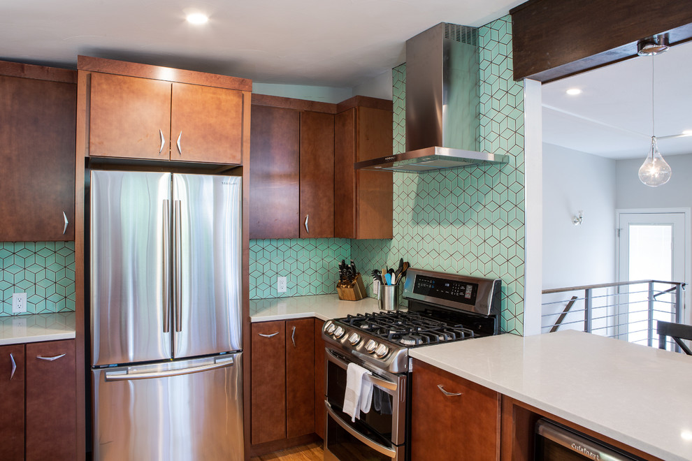 Inspiration for a mid-sized midcentury u-shaped eat-in kitchen in Denver with an undermount sink, flat-panel cabinets, medium wood cabinets, quartz benchtops, green splashback, ceramic splashback, stainless steel appliances, light hardwood floors, with island, brown floor and white benchtop.