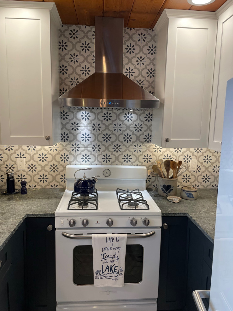 Inspiration for a small country kitchen in Other with a belfast sink, shaker cabinets, blue cabinets, soapstone worktops, white splashback, metro tiled splashback, white appliances, porcelain flooring, grey floors and a wood ceiling.