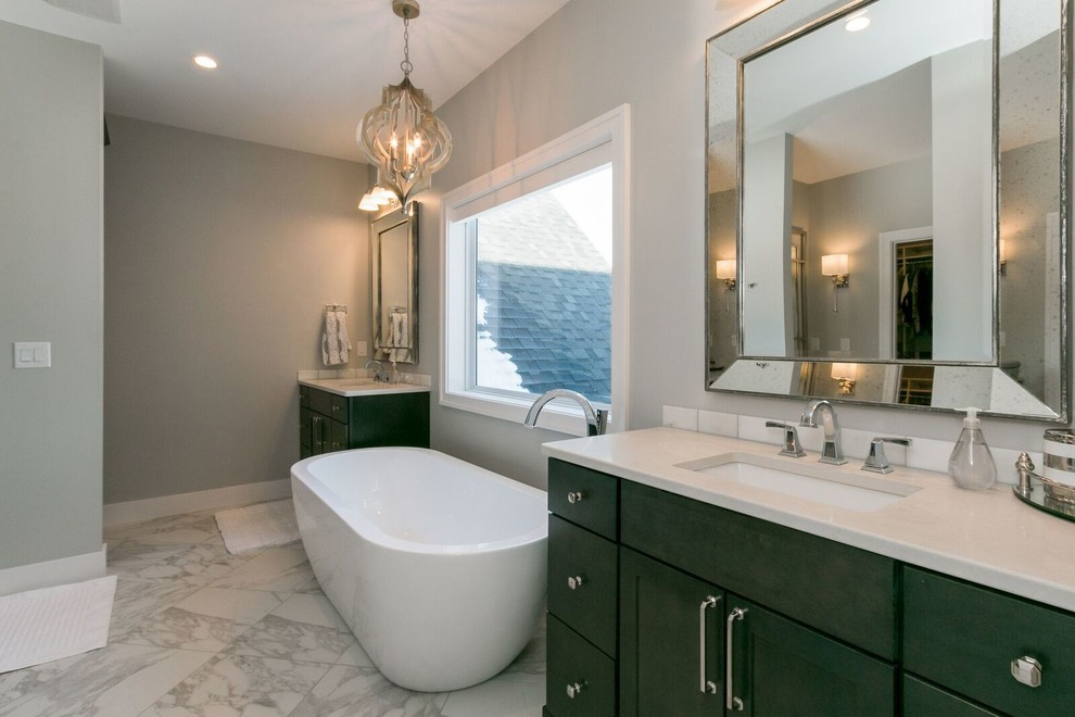 Inspiration for a mid-sized transitional ceramic tile marble floor freestanding bathtub remodel in Cedar Rapids with flat-panel cabinets, black cabinets, gray walls and an undermount sink