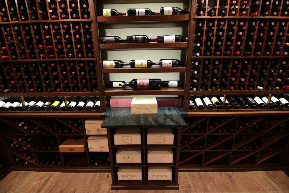 This is an example of a mid-sized traditional wine cellar in Cincinnati with laminate floors, storage racks and brown floor.