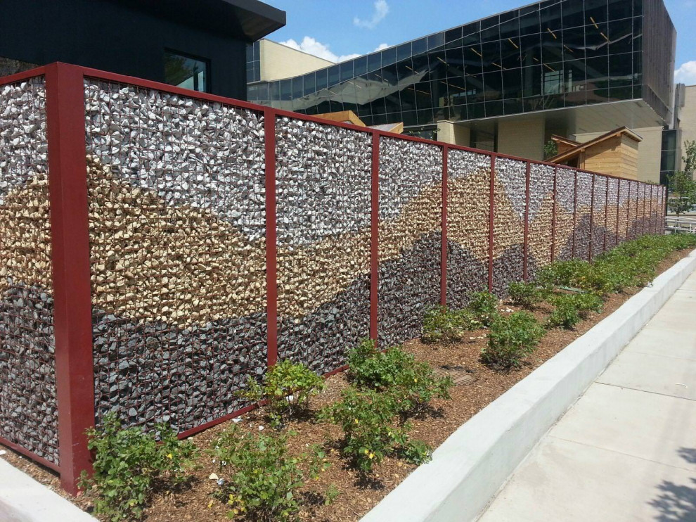 Esempio di un giardino formale minimalista esposto in pieno sole davanti casa con un muro di contenimento e recinzione in metallo