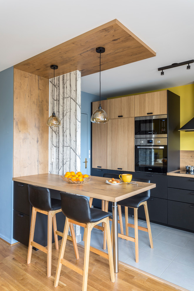 Photo of a mid-sized contemporary l-shaped eat-in kitchen in Paris with wood benchtops, timber splashback, with island and grey floor.