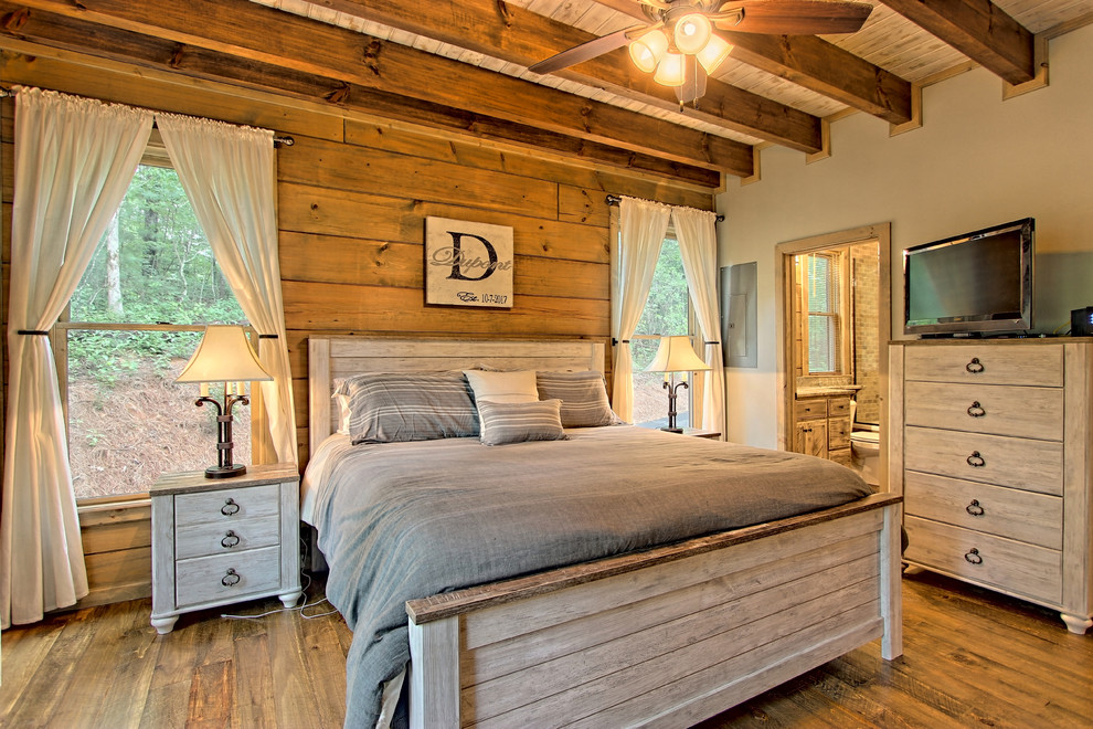 Design ideas for a small country master bedroom in Other with grey walls, painted wood floors and brown floor.