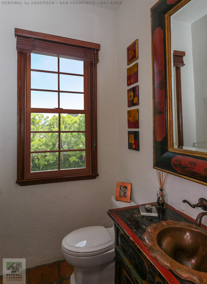 Стильный дизайн: маленькая ванная комната с искусственно-состаренными фасадами, раздельным унитазом, коричневой плиткой, бежевыми стенами, полом из терракотовой плитки, накладной раковиной, красным полом, черной столешницей, тумбой под одну раковину, встроенной тумбой и сводчатым потолком для на участке и в саду - последний тренд