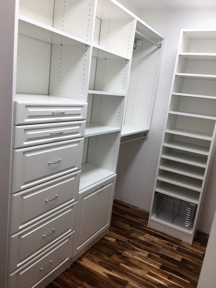 This is an example of a mid-sized transitional gender-neutral walk-in wardrobe in Indianapolis with raised-panel cabinets, white cabinets, dark hardwood floors and brown floor.