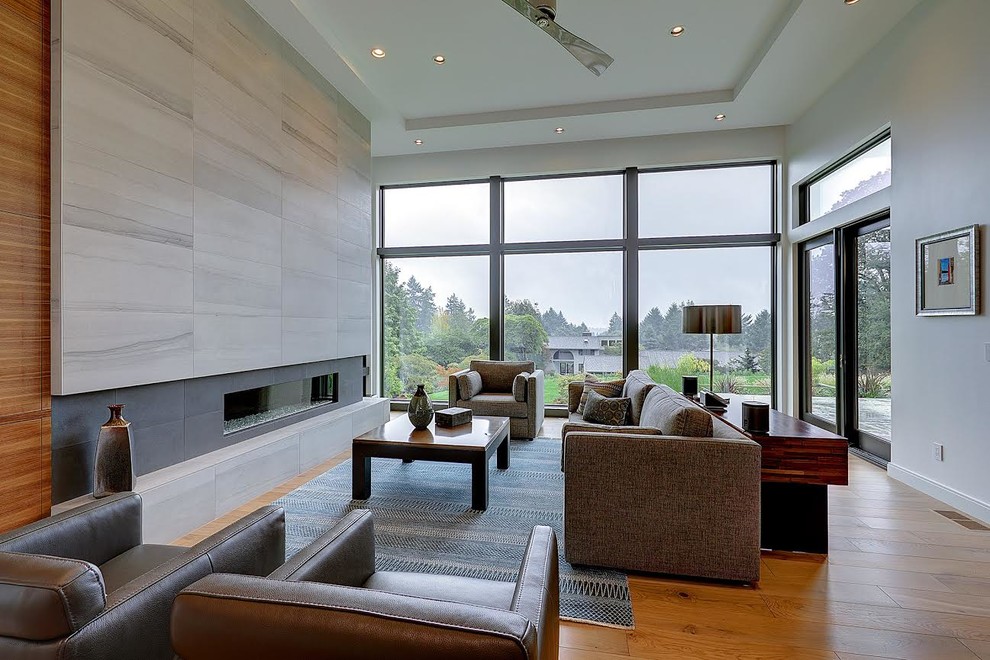 Photo of a large contemporary formal open concept living room in Portland with grey walls, medium hardwood floors, a ribbon fireplace, a plaster fireplace surround, no tv and orange floor.