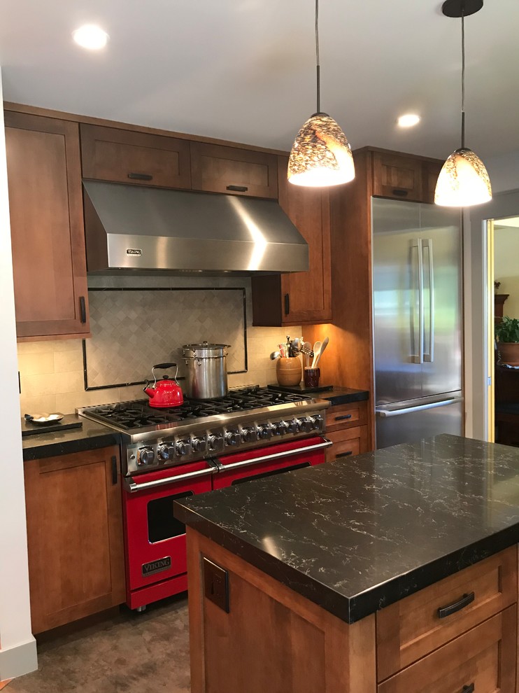 Mid-sized arts and crafts u-shaped eat-in kitchen in San Francisco with a single-bowl sink, shaker cabinets, medium wood cabinets, quartz benchtops, beige splashback, stainless steel appliances, cork floors, with island, multi-coloured floor, black benchtop and stone tile splashback.