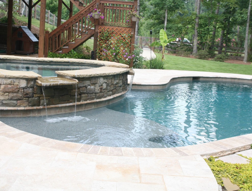 Mid-sized trendy backyard stone and custom-shaped natural hot tub photo