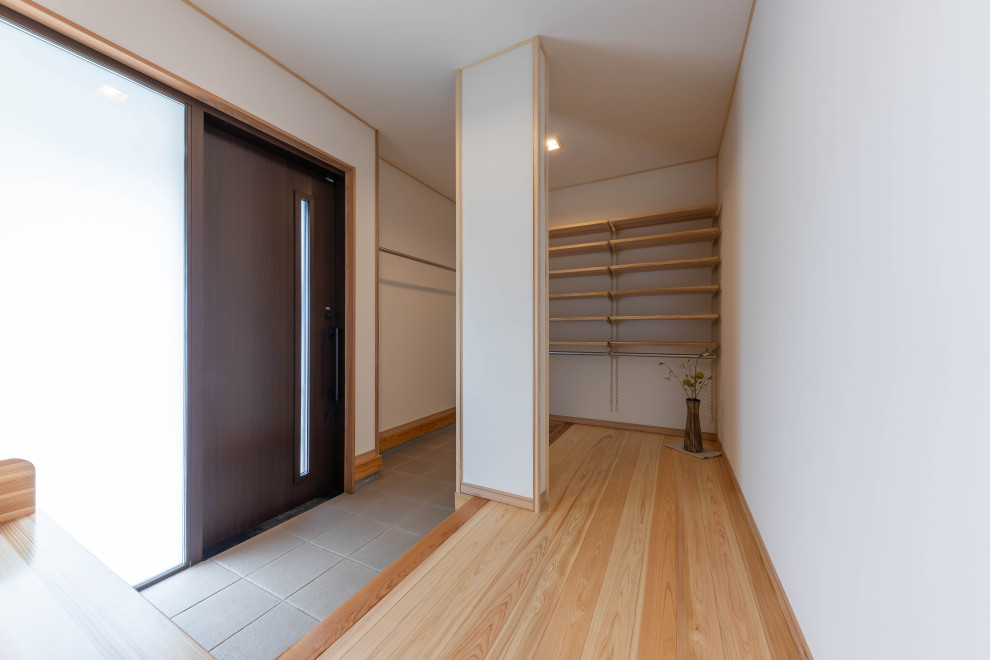 Imagen de hall blanco asiático de tamaño medio con paredes blancas, suelo de madera en tonos medios, puerta corredera, puerta de madera oscura, suelo beige, papel pintado y papel pintado