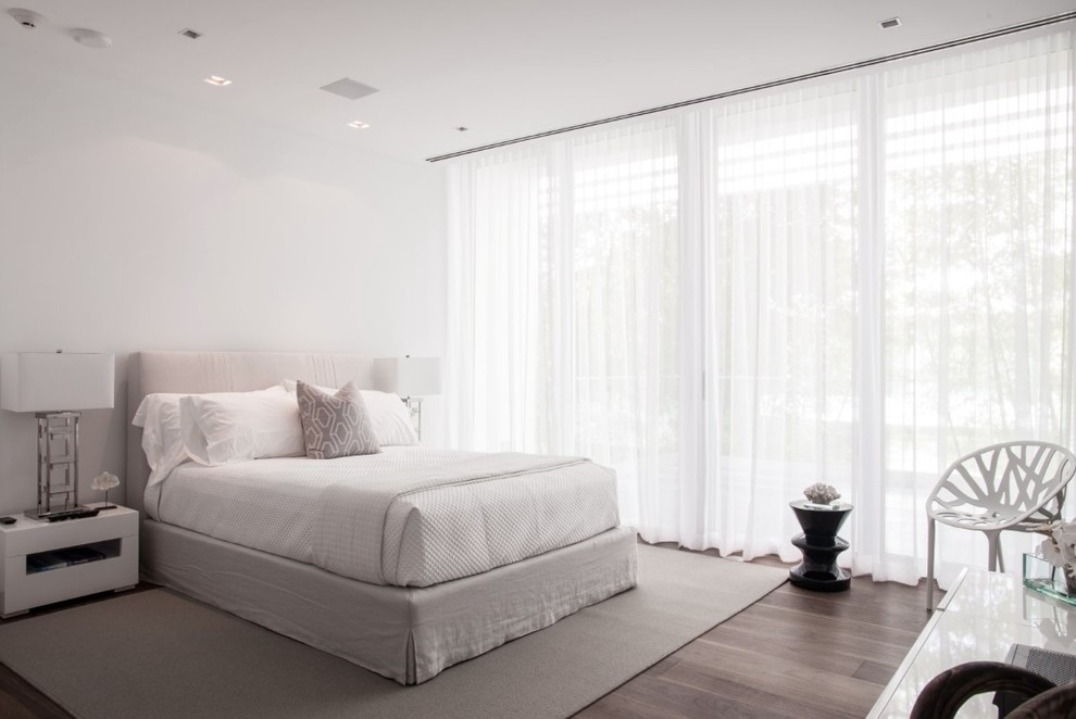 Mid-sized contemporary guest bedroom in Miami with white walls, light hardwood floors, no fireplace and brown floor.
