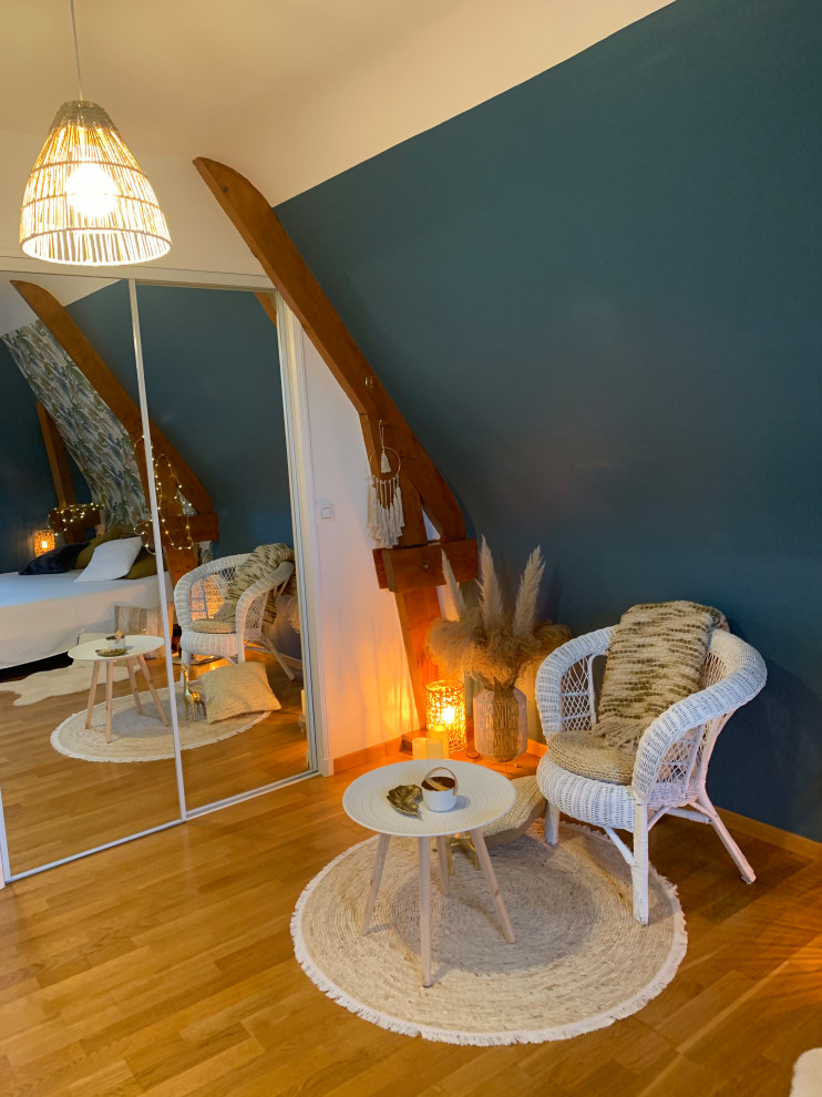 Mittelgroßes Schlafzimmer ohne Kamin, im Loft-Style mit blauer Wandfarbe, hellem Holzboden, braunem Boden, freigelegten Dachbalken und Tapetenwänden in Sonstige