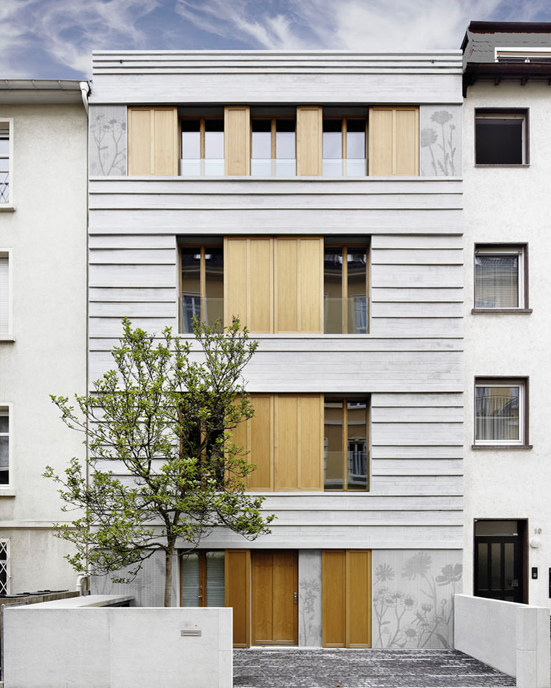 Inspiration for a mid-sized three-storey grey apartment exterior in Frankfurt with stone veneer and a gable roof.