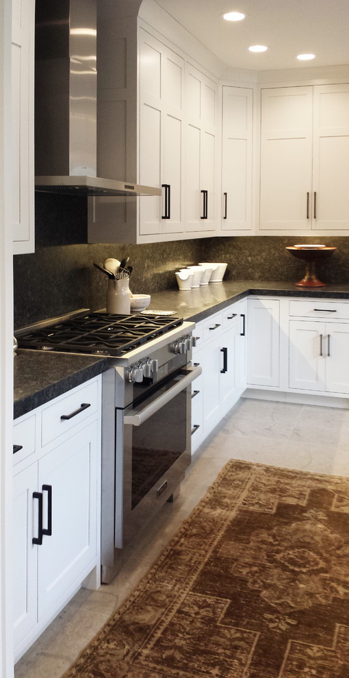 Example of a mid-sized transitional l-shaped concrete floor and beige floor eat-in kitchen design with an undermount sink, shaker cabinets, white cabinets, granite countertops, black backsplash, stone slab backsplash, paneled appliances and a peninsula