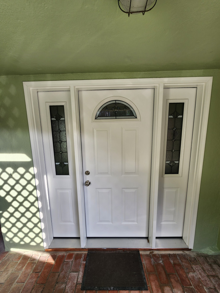 Photo of a small traditional front door in San Francisco with green walls, carpet, a single front door, a white front door and grey floor.
