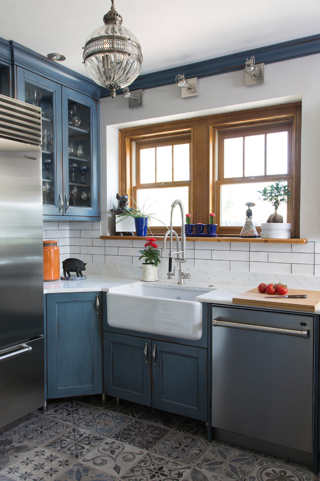 Mid-sized traditional u-shaped kitchen in Denver with a farmhouse sink, open cabinets, blue cabinets, quartz benchtops, white splashback, subway tile splashback, stainless steel appliances, ceramic floors, a peninsula, blue floor and white benchtop.