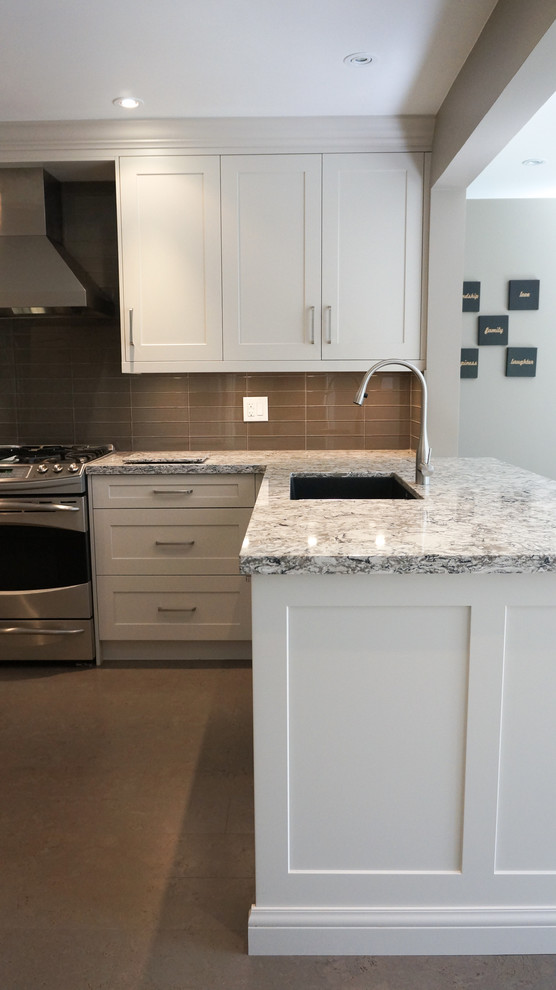 Large transitional u-shaped enclosed kitchen photo in Toronto with an undermount sink, shaker cabinets, white cabinets, quartz countertops, brown backsplash, glass tile backsplash, stainless steel appliances and a peninsula