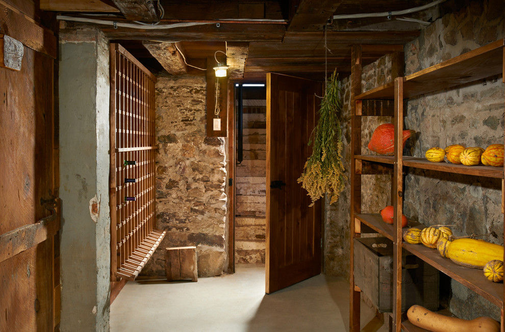 Mid-sized country wine cellar in Toronto with concrete floors and storage racks.