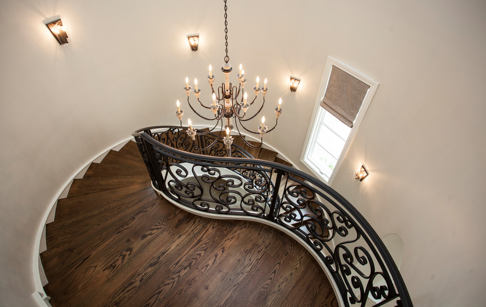 Design ideas for a large mediterranean wood curved staircase in Other with wood risers and metal railing.