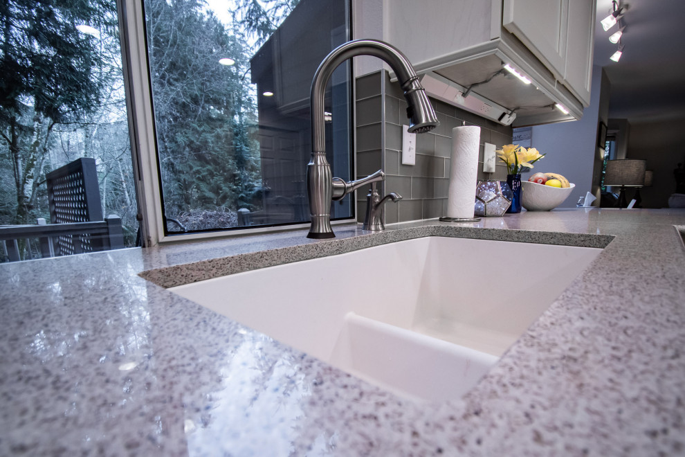 Transitional u-shaped medium tone wood floor open concept kitchen photo in Seattle with an undermount sink, shaker cabinets, white cabinets, quartz countertops, gray backsplash, glass tile backsplash, stainless steel appliances, a peninsula and multicolored countertops