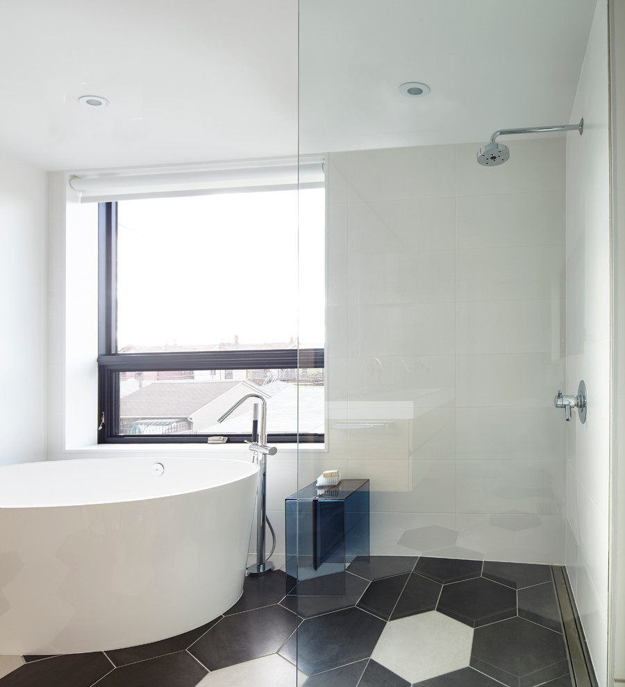 Design ideas for a mid-sized contemporary master bathroom in Toronto with flat-panel cabinets, light wood cabinets, a freestanding tub, an open shower, white tile, stone tile, white walls, porcelain floors, a trough sink and solid surface benchtops.