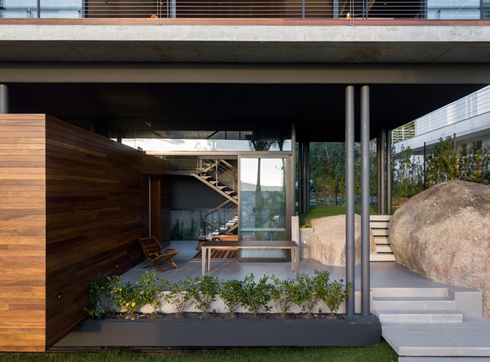 Photo of a mid-sized modern side yard verandah in Other with tile.