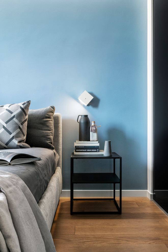 Esempio di una camera matrimoniale minimal di medie dimensioni con pareti blu e parquet scuro