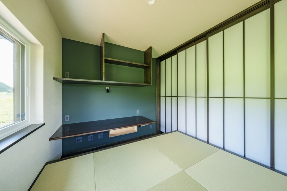 Inredning av ett modernt mellanstort hemmabibliotek, med gröna väggar, tatamigolv, ett inbyggt skrivbord och grönt golv