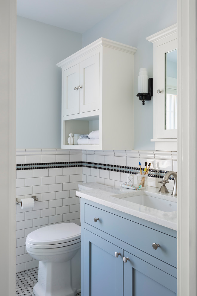 Design ideas for a small traditional kids bathroom in Minneapolis with blue cabinets, a corner shower, a two-piece toilet, black and white tile, ceramic tile, blue walls, marble floors, an undermount sink, engineered quartz benchtops, grey floor, a hinged shower door, white benchtops and shaker cabinets.